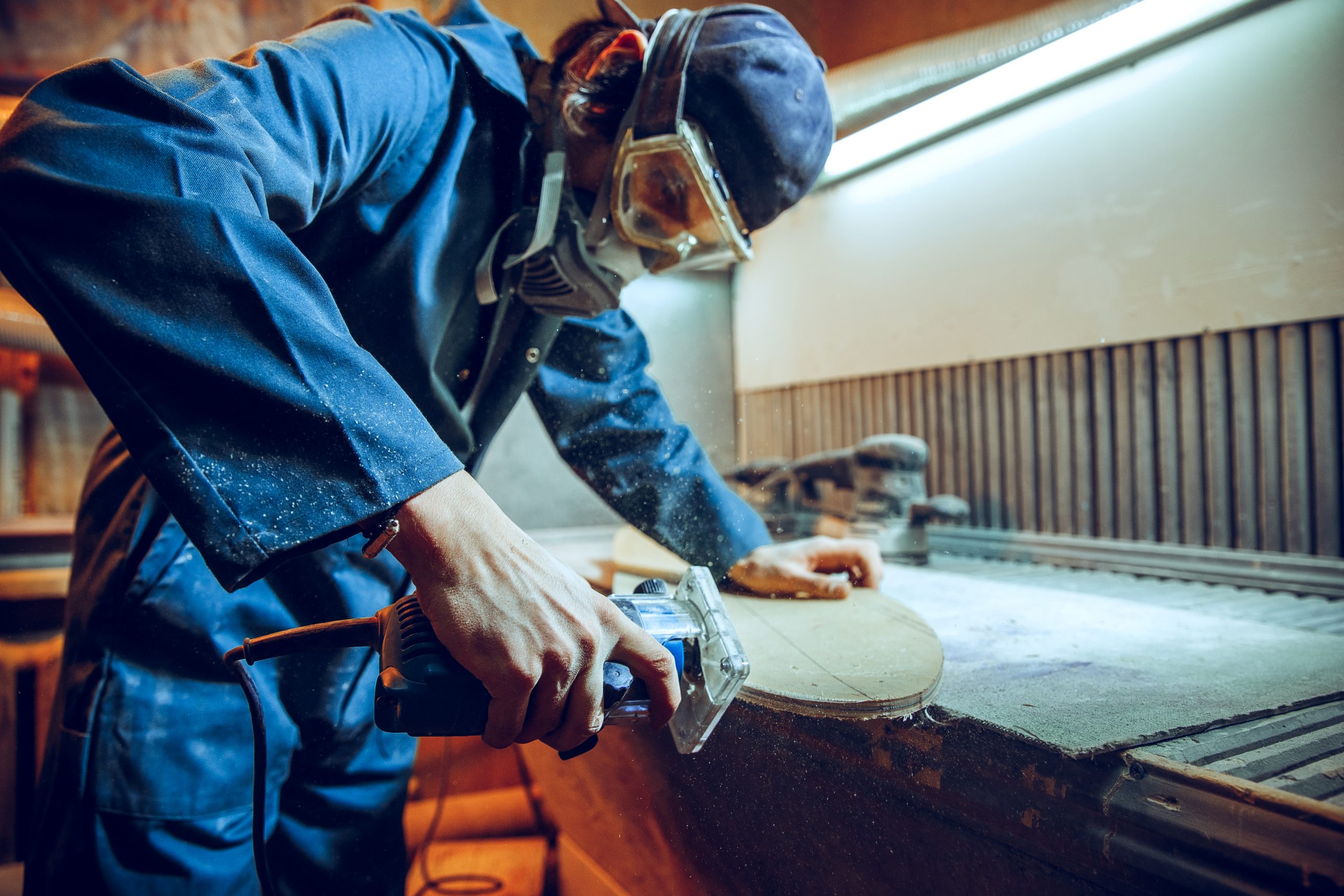 Carpenter using circular saw for cutting wooden boards. Construction details of male worker or handy man with power tools